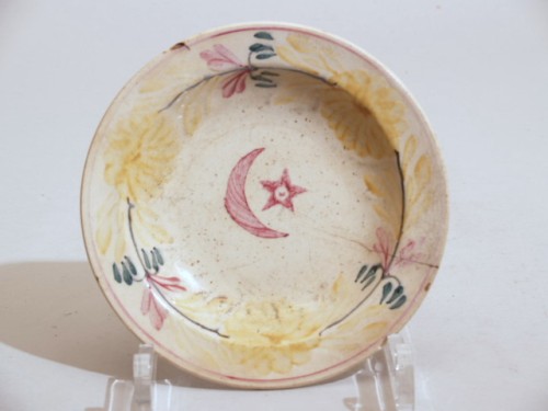 Bord met polychroom decor van ster en Turkse halve maan en bloemslinger